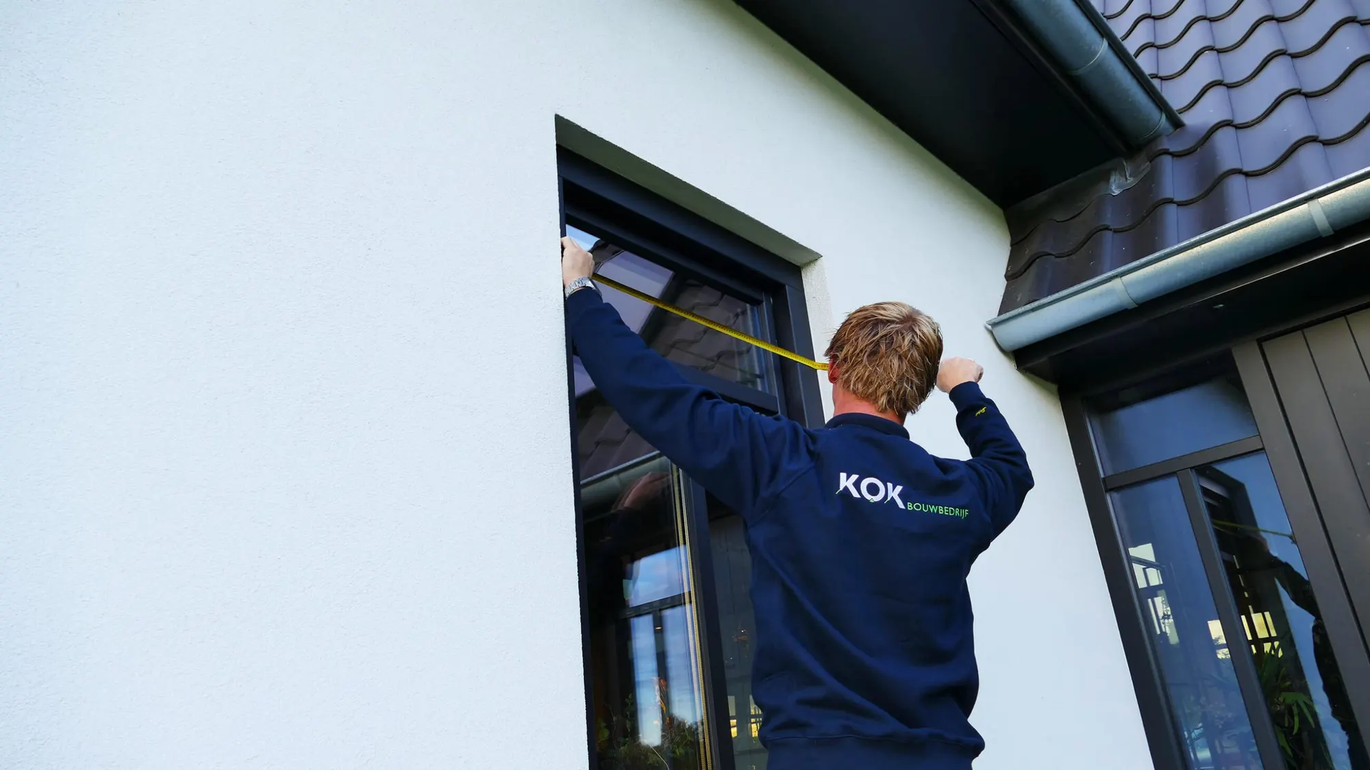 Timmerman van Bouwbedrijf Kok meet een kozijn in tijdens de afbouw