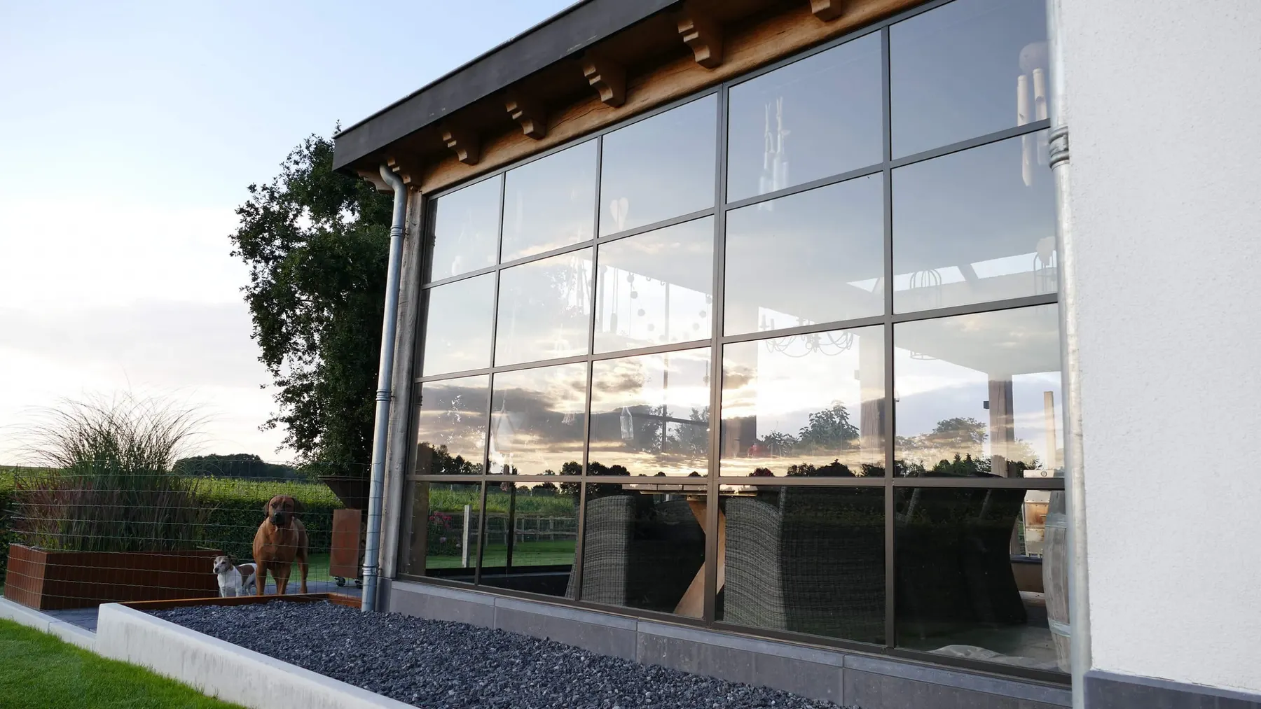 Moderne glasgevel met wit stucwerk en een eiken dakconstructie