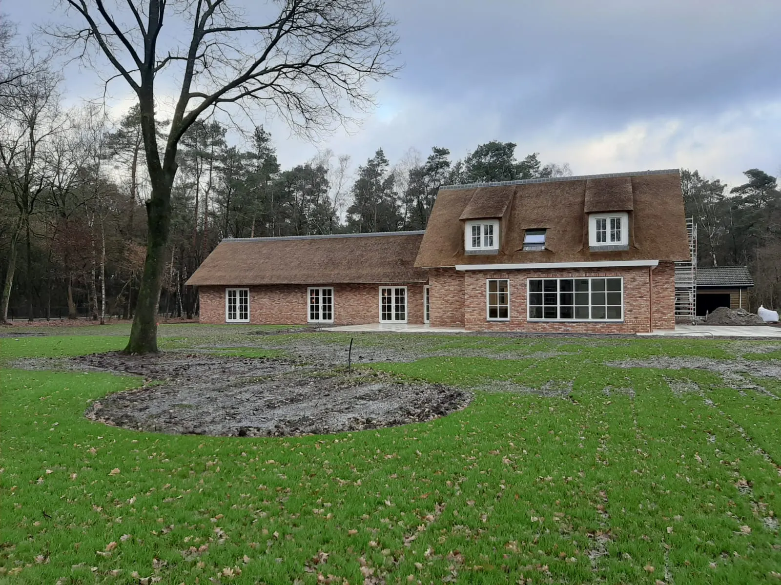 Landhuis met rieten kap tussen de bomen op de Veluwe